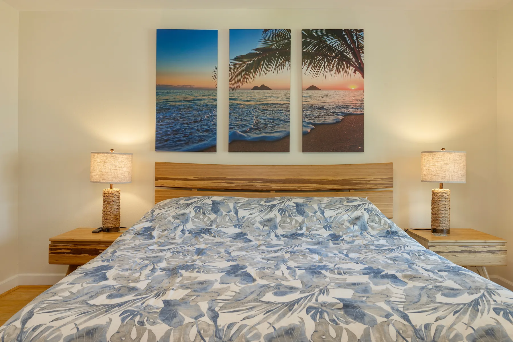 Un dormitorio con una cama bajo tres cuadros de playa.