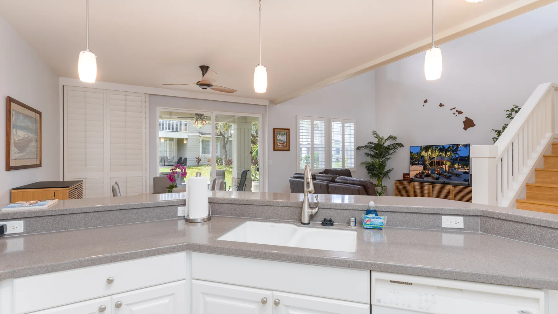 Una cocina luminosa y sala de estar diáfanas, con una barra amplia y asientos.