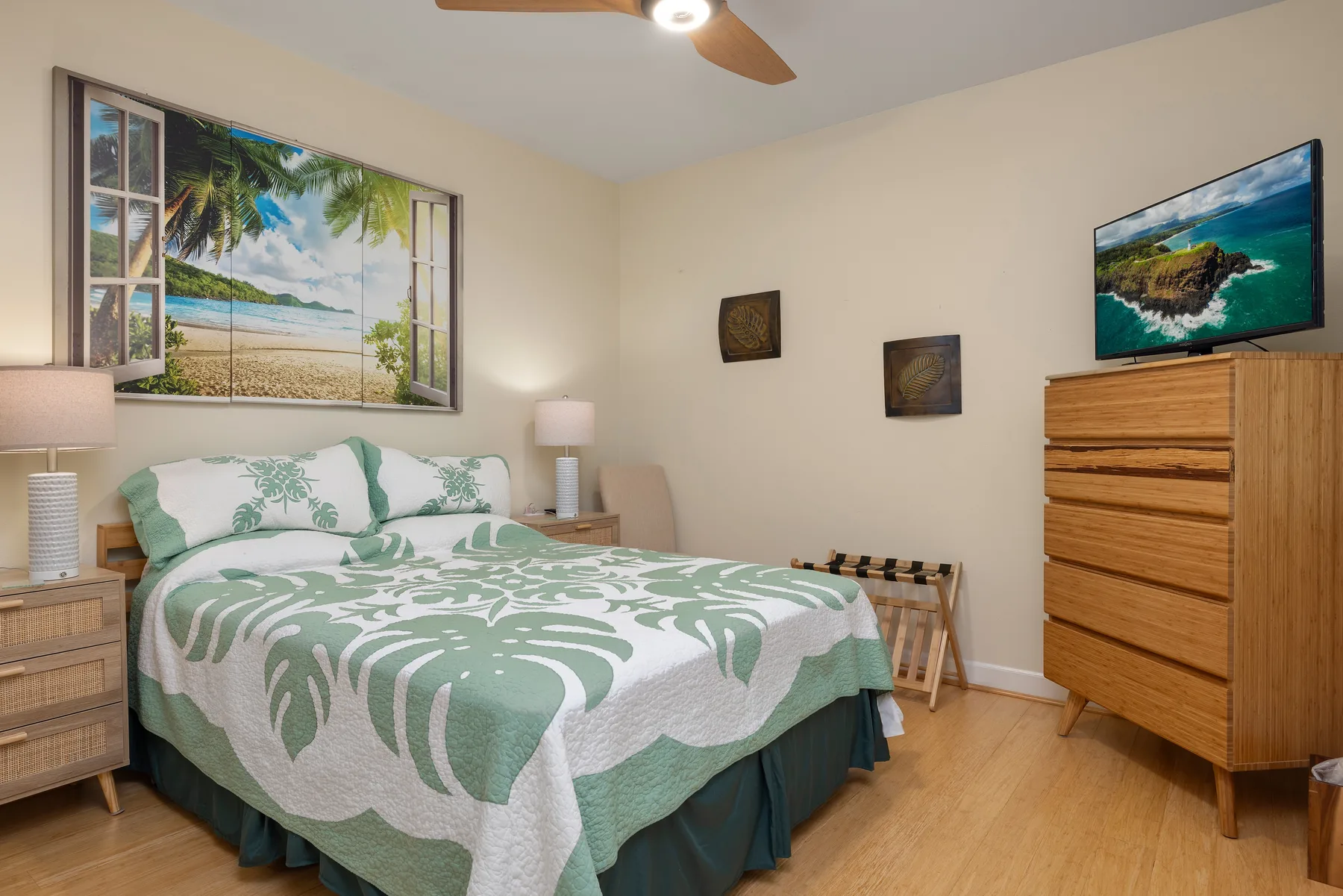 Un dormitorio con una cama cubierta con una colcha estampada verde y blanca.