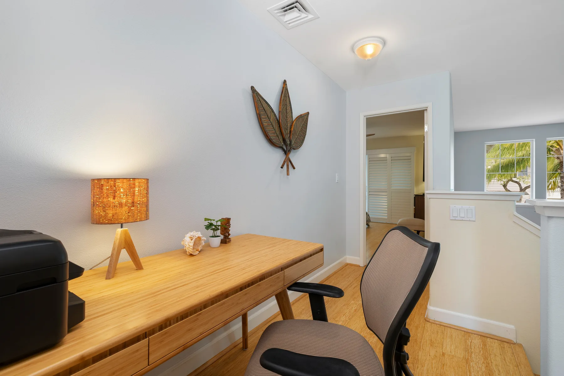 Un estudio luminoso con un escritorio de madera y una silla.