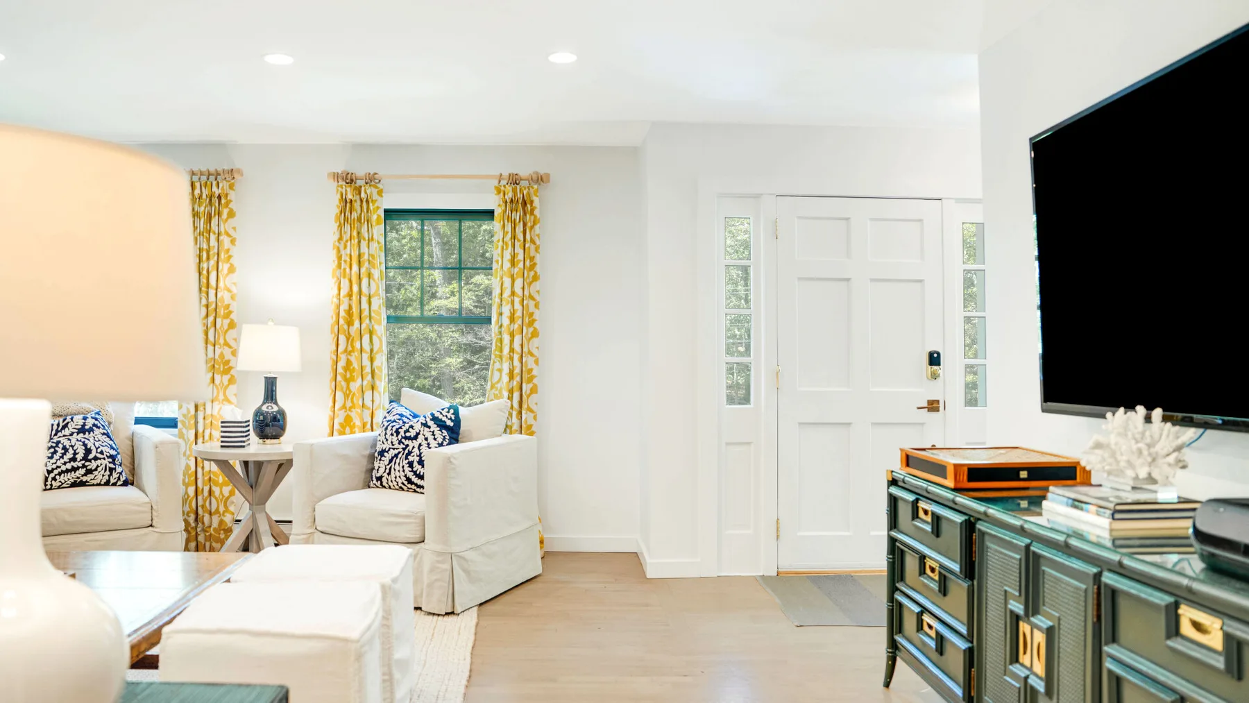 Una sala luminosa con asientos, una ventana y un televisor.