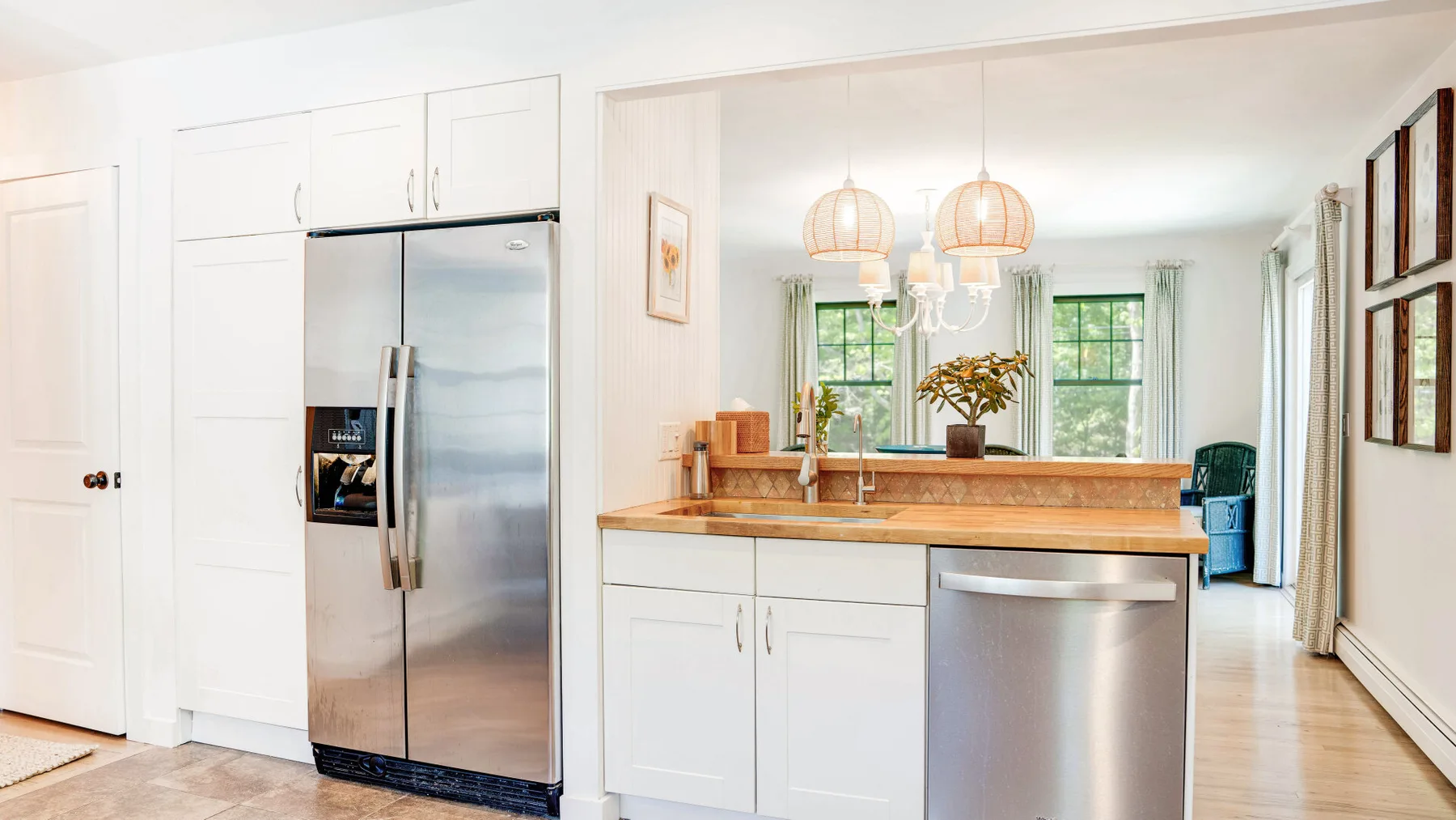 Una cocina luminosa con un refrigerador de acero inoxidable y una isla central.