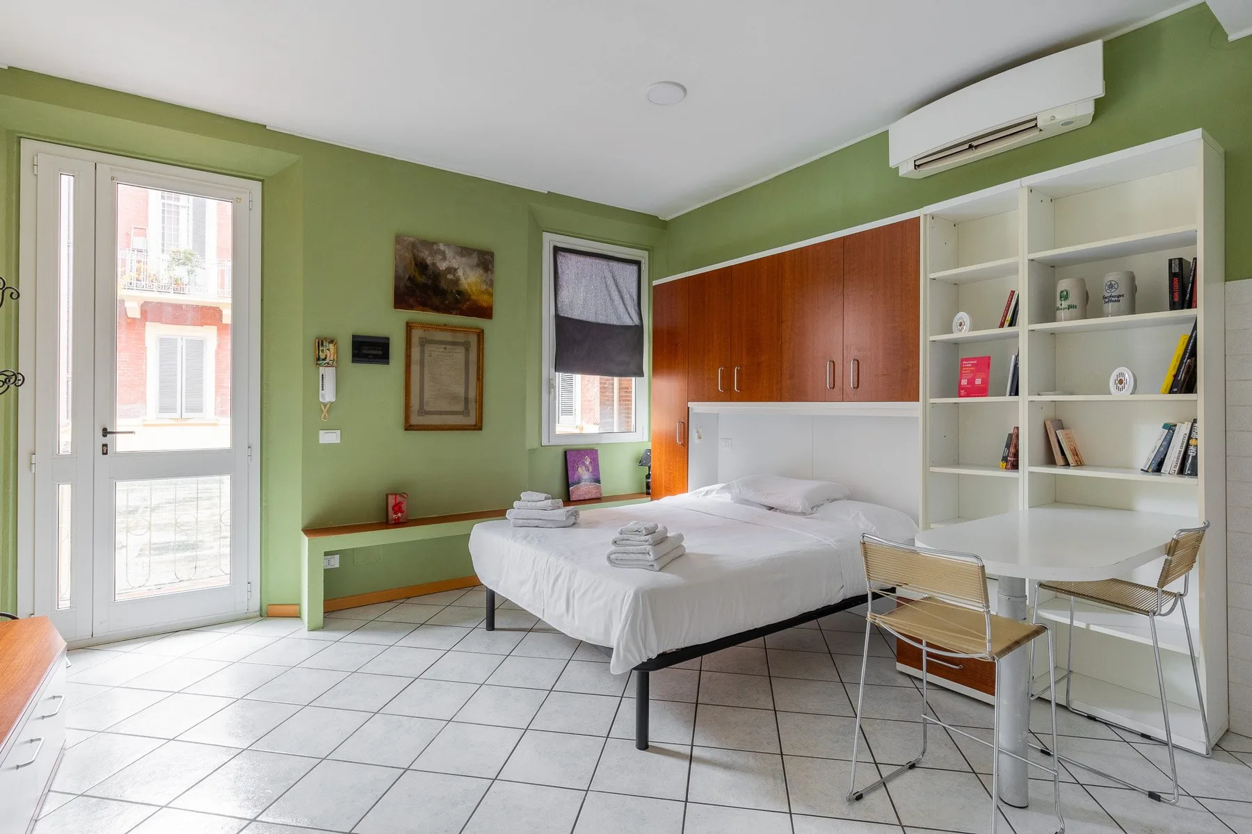 Un dormitorio con una cama y un escritorio con estanterías.