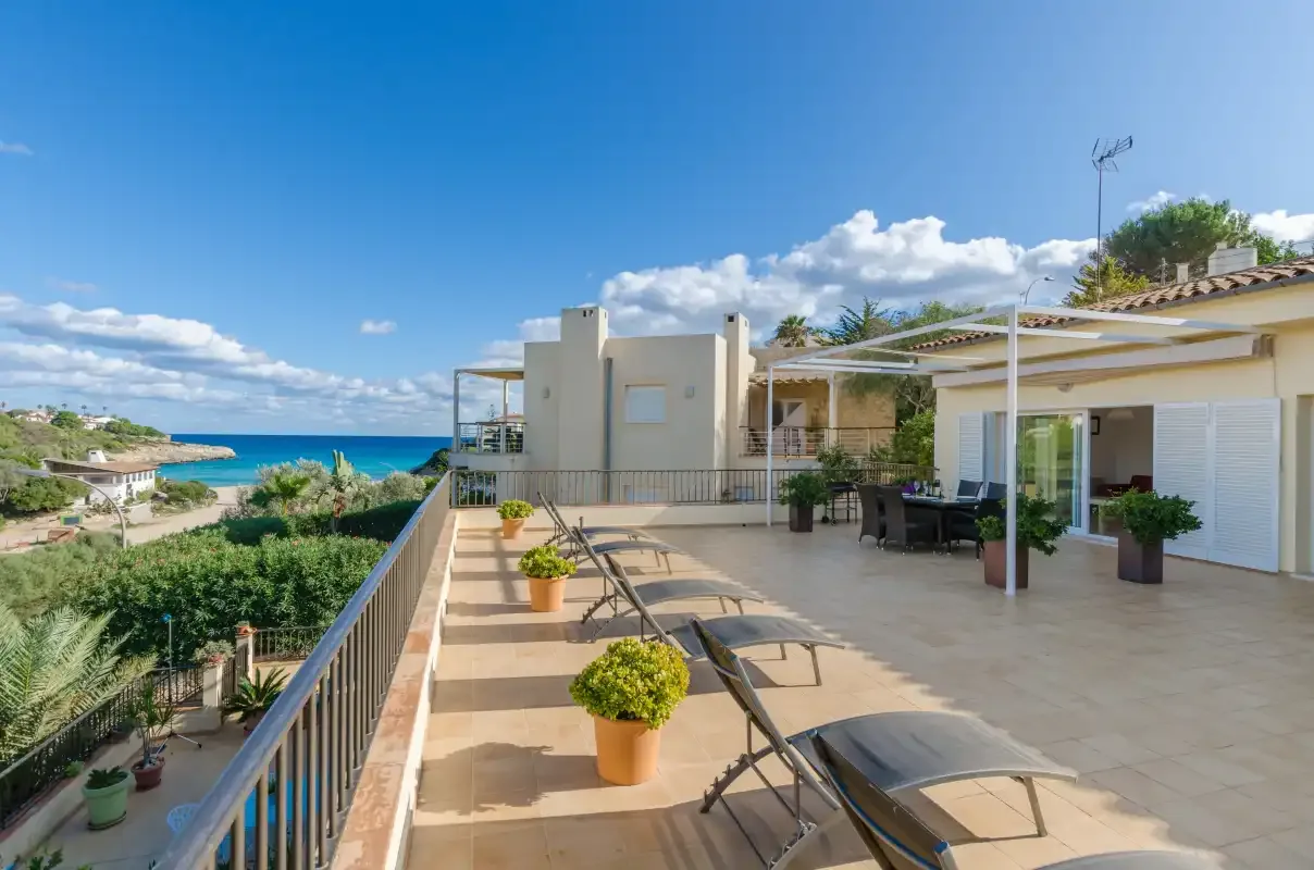 Una terraza soleada con asientos de descanso ofrece vistas al mar.