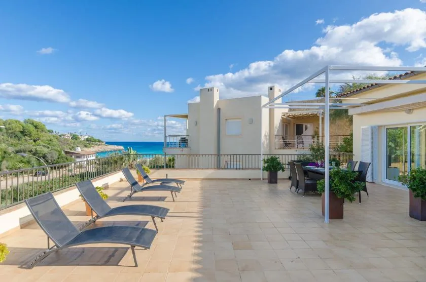 Una amplia terraza en la azotea tiene asientos y vistas al mar.