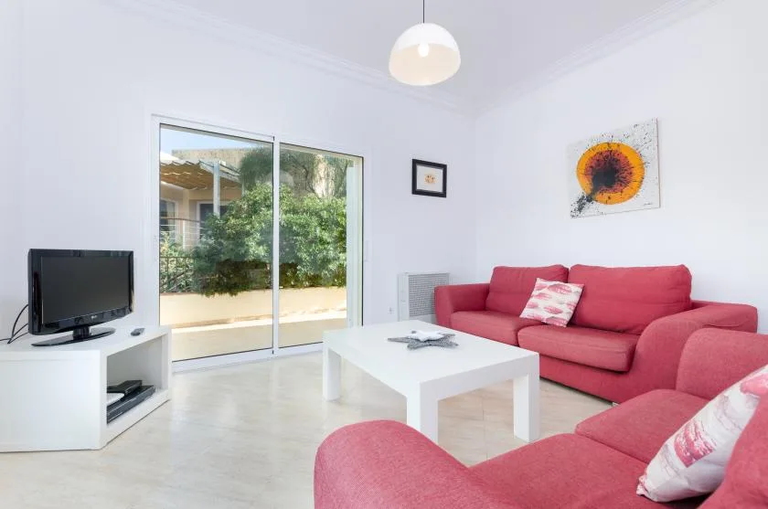 Una sala luminosa con asientos rosas y una mesa de centro blanca.
