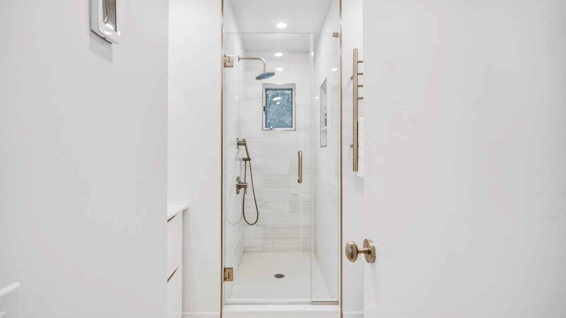 A bright bathroom with a glass-enclosed shower.