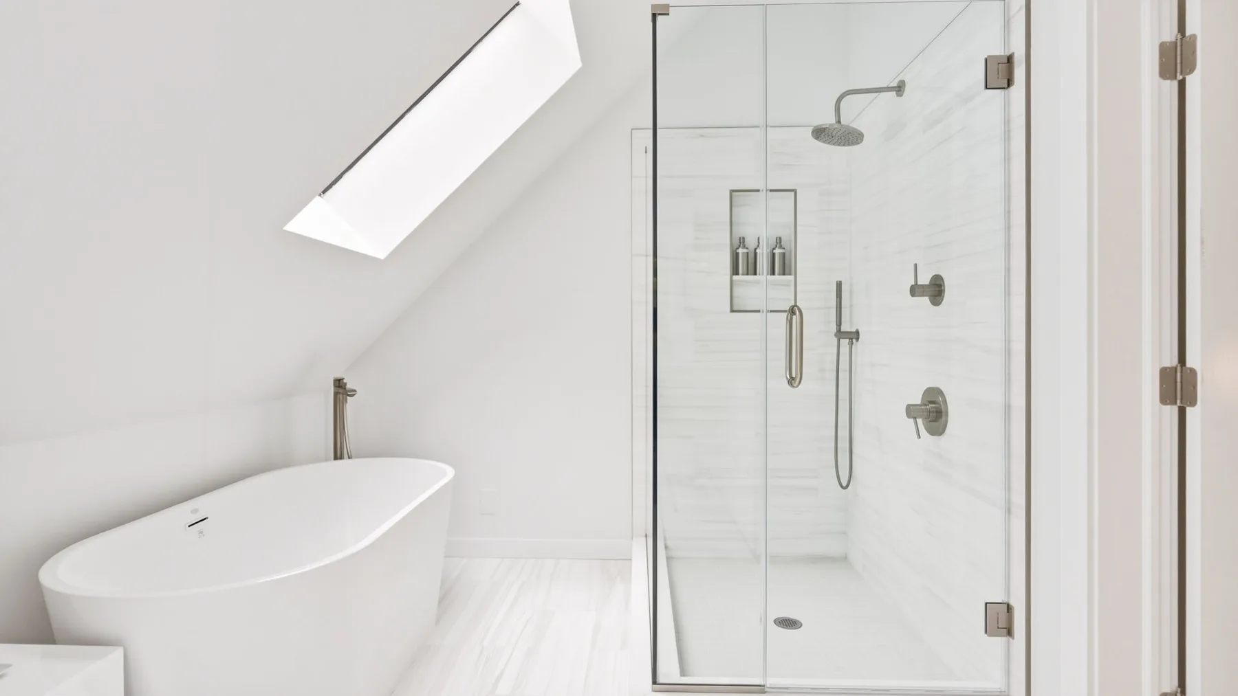 A bright bathroom with a freestanding bathtub and glass-enclosed shower.