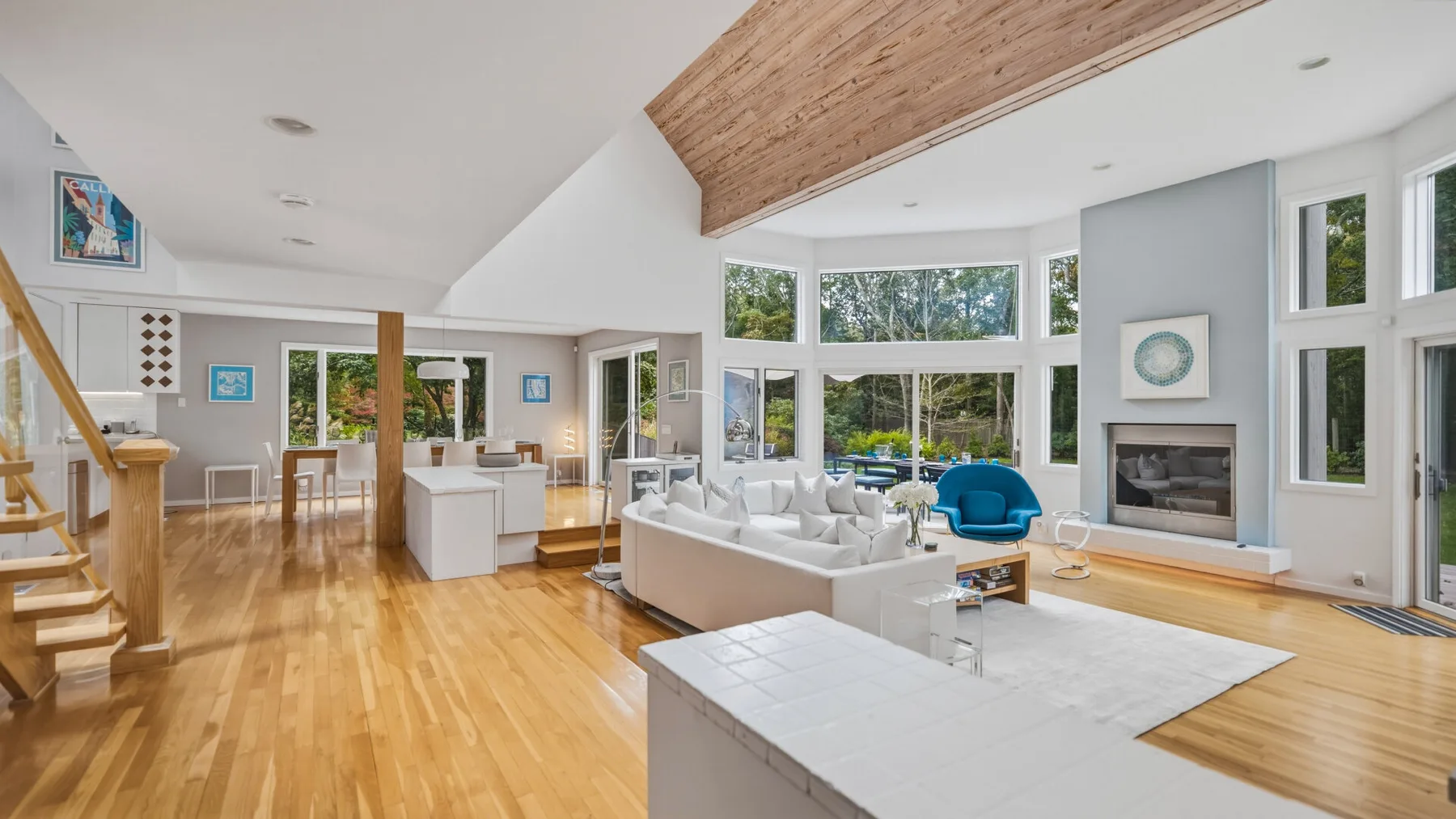 A bright open-plan living room with large windows and a seating area.