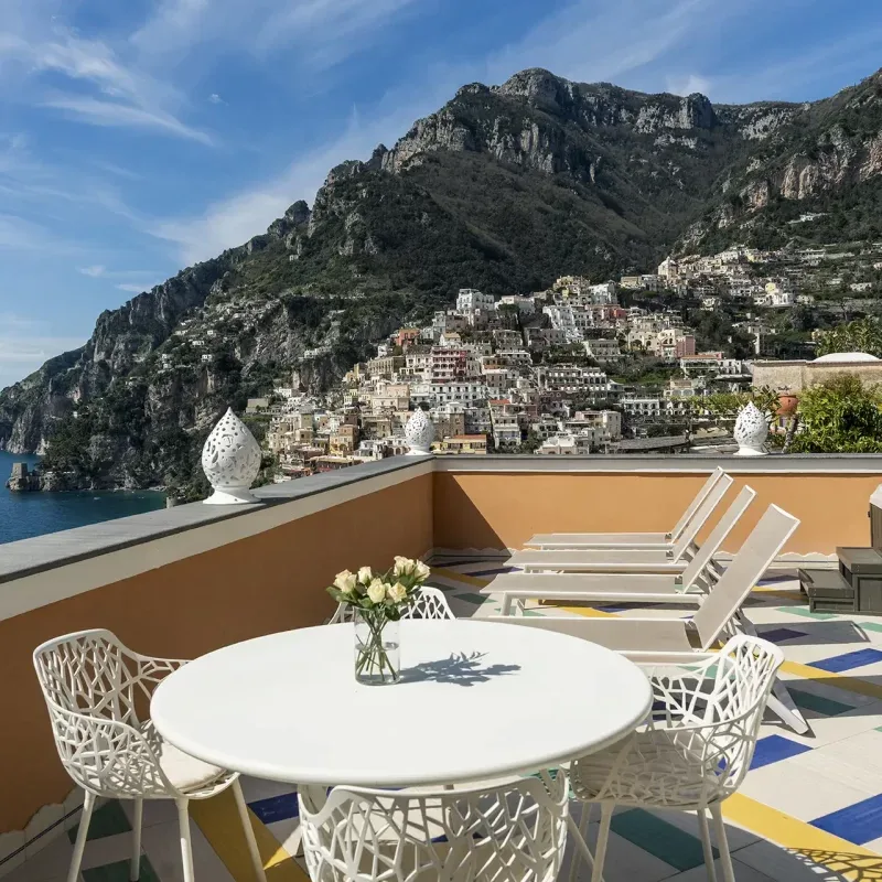 Terrace overlooking a coastal town and surrounding mountains.