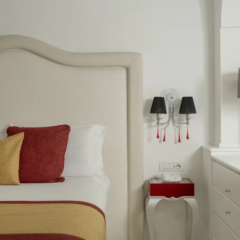 Bedroom with decorative pillows and a modern lamp.