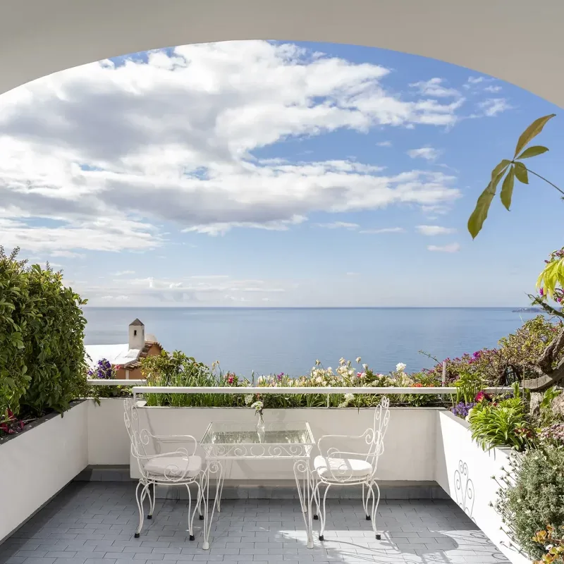 Terrace with table and panoramic sea views.