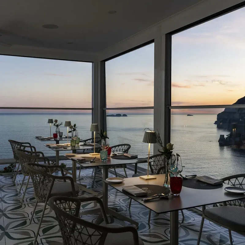 Dining terrace overlooking the sea at sunset.
