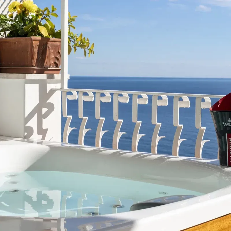 Hot tub on a balcony overlooking the sea.