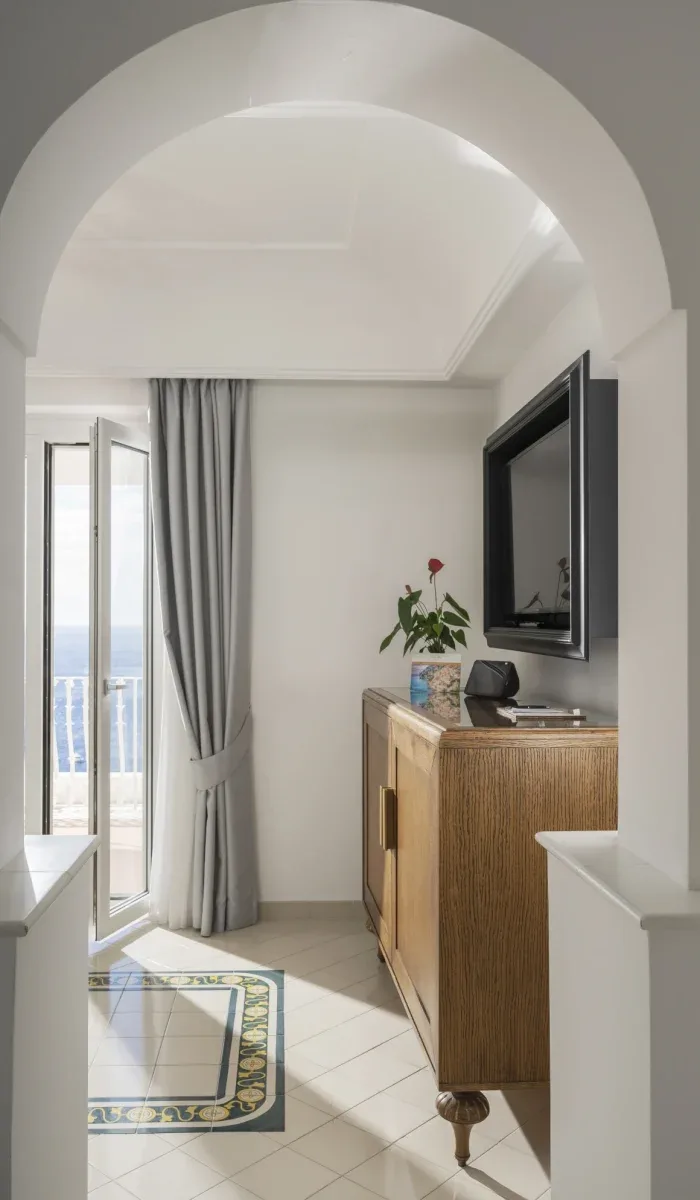 Bright room with an arched entry, sea view and wooden cabinet.