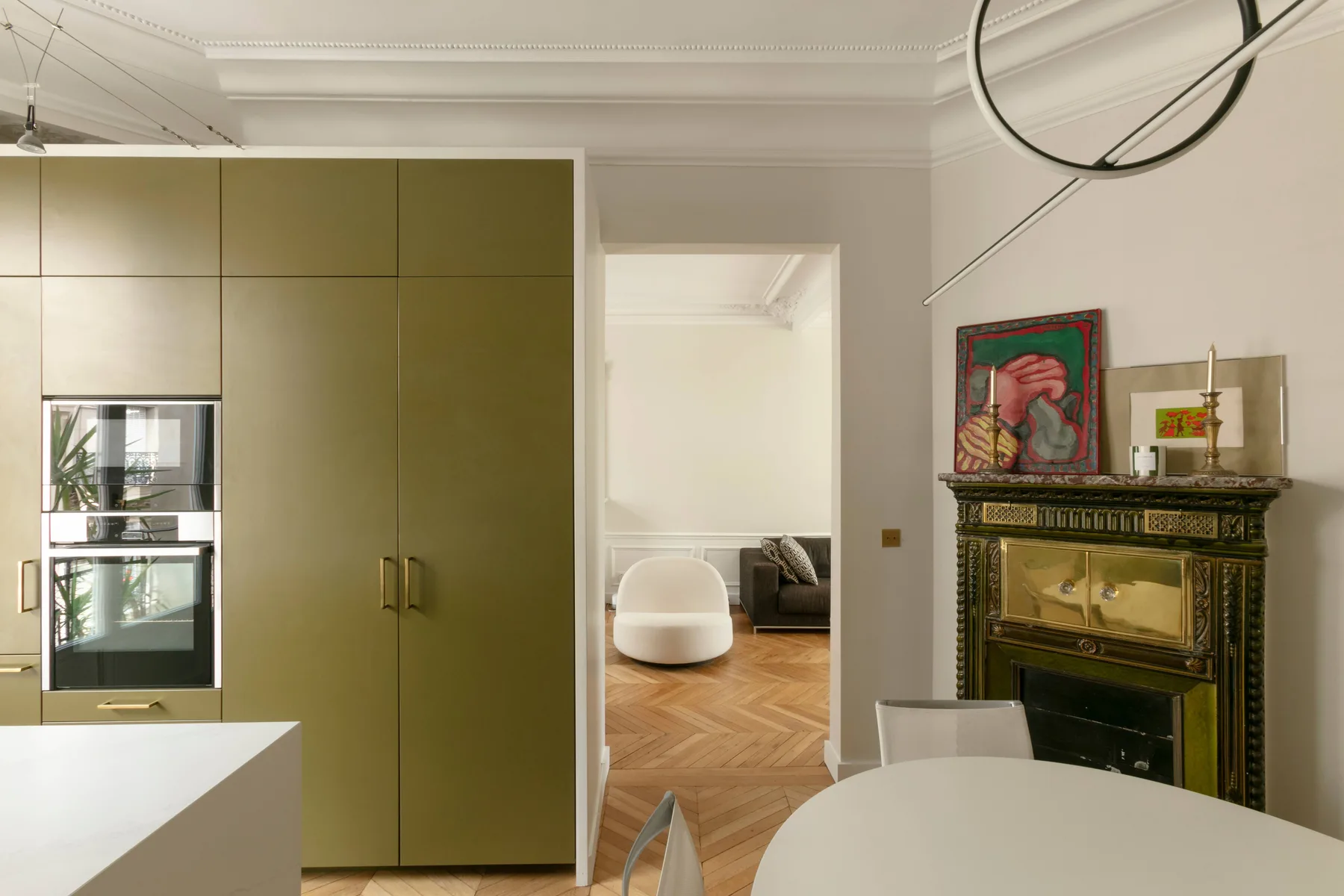 Una cocina moderna se abre a una sala de estar, con una chimenea decorativa junto a la puerta.