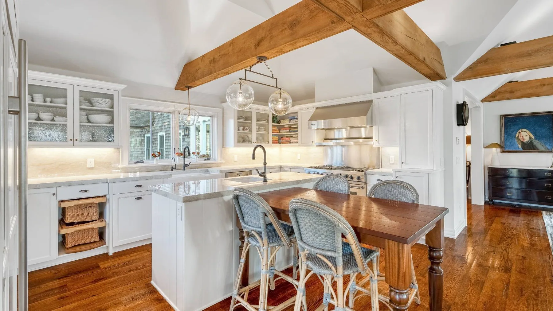 A bright kitchen and dining area with a central island and wooden table.