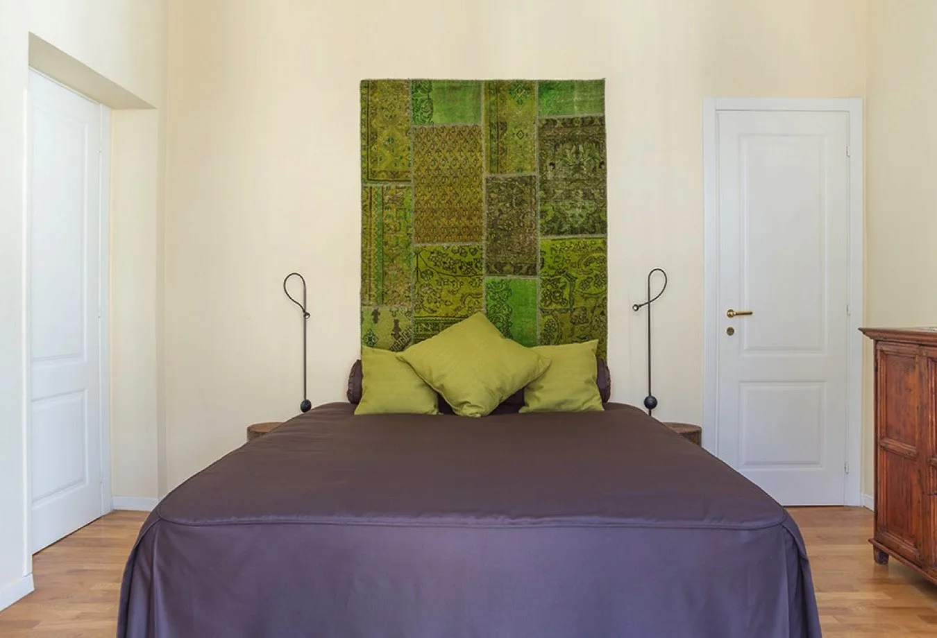Un dormitorio con una cama y una obra de arte verde estampada encima.