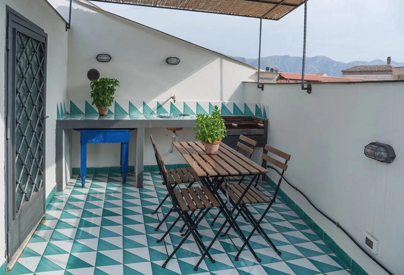 Una terraza en la azotea con asientos al aire libre y suelo de baldosas estampadas.