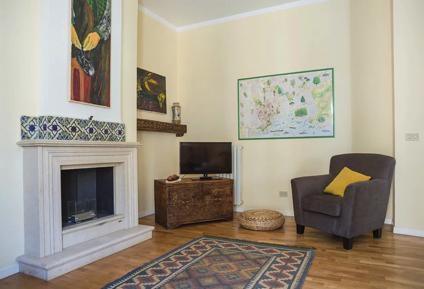 Una sala de estar con chimenea, televisor y sillón.