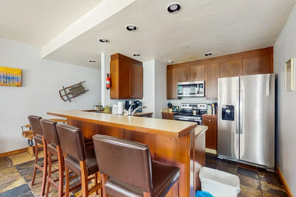 A kitchen with a wood-finished island and stainless steel appliances.