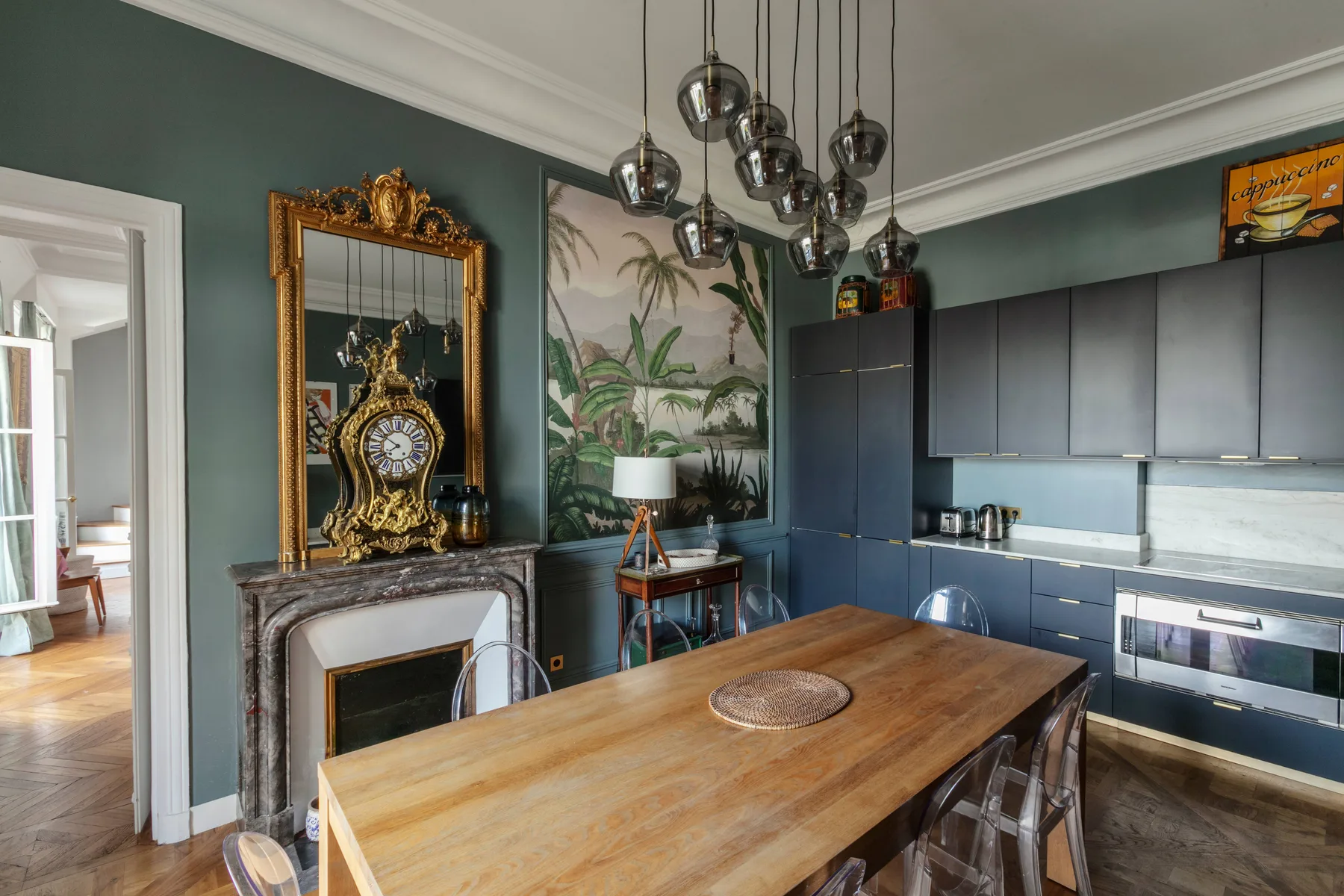 Comedor con una mesa de madera, una chimenea ornamentada y gabinetes oscuros.