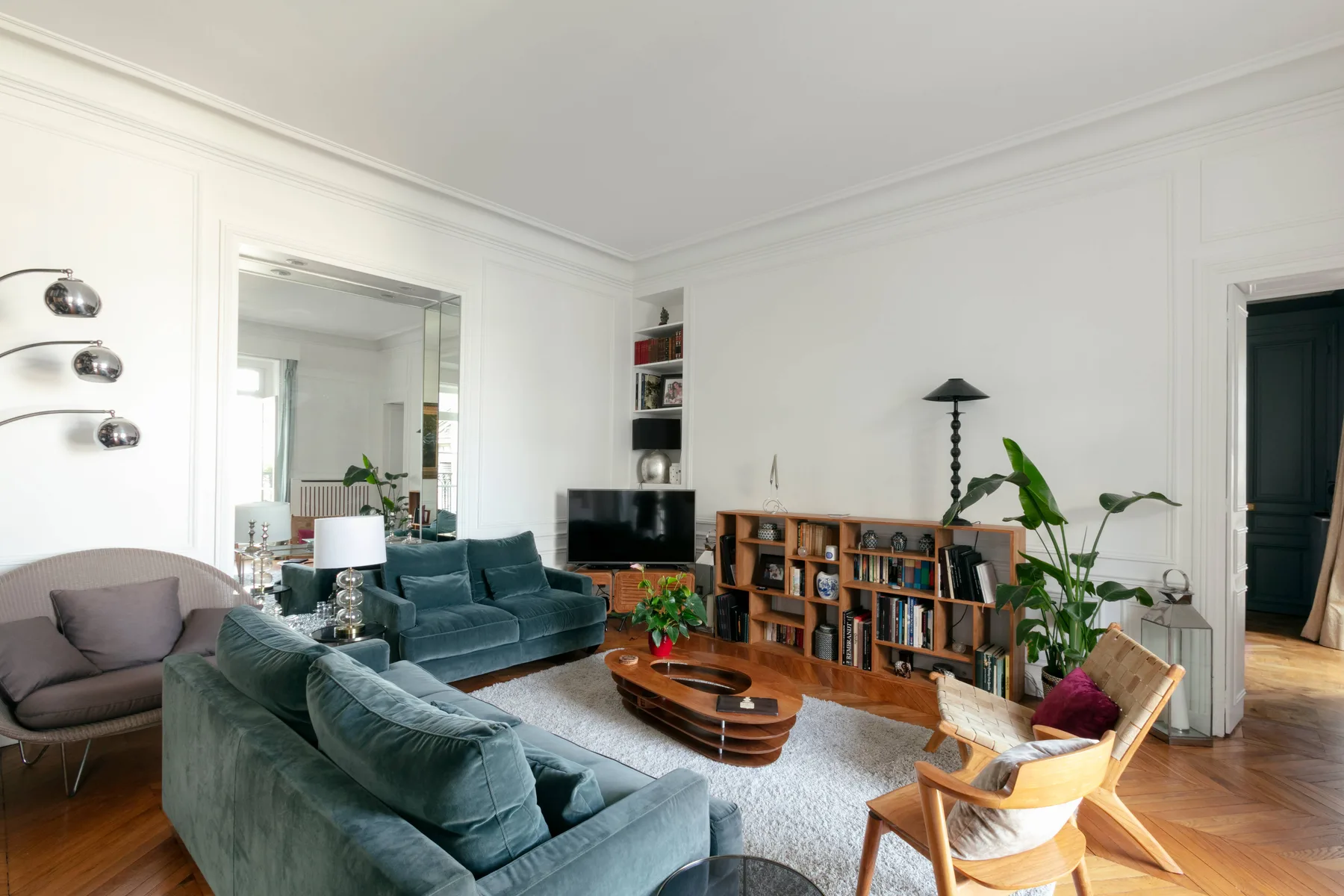Una sala luminosa con asientos, un televisor y estanterías.