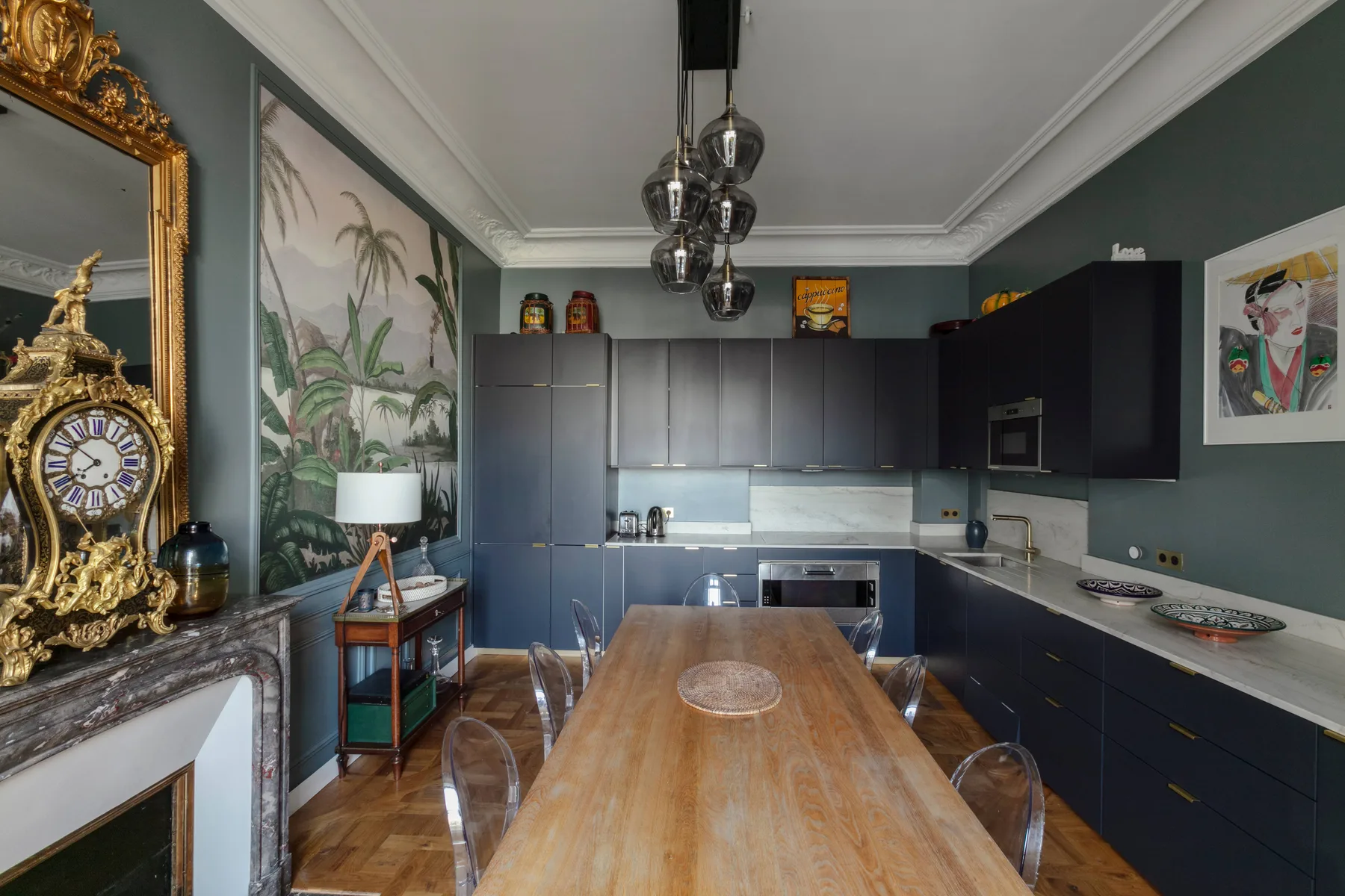 Una cocina y comedor con gabinetes oscuros y una mesa larga de madera.