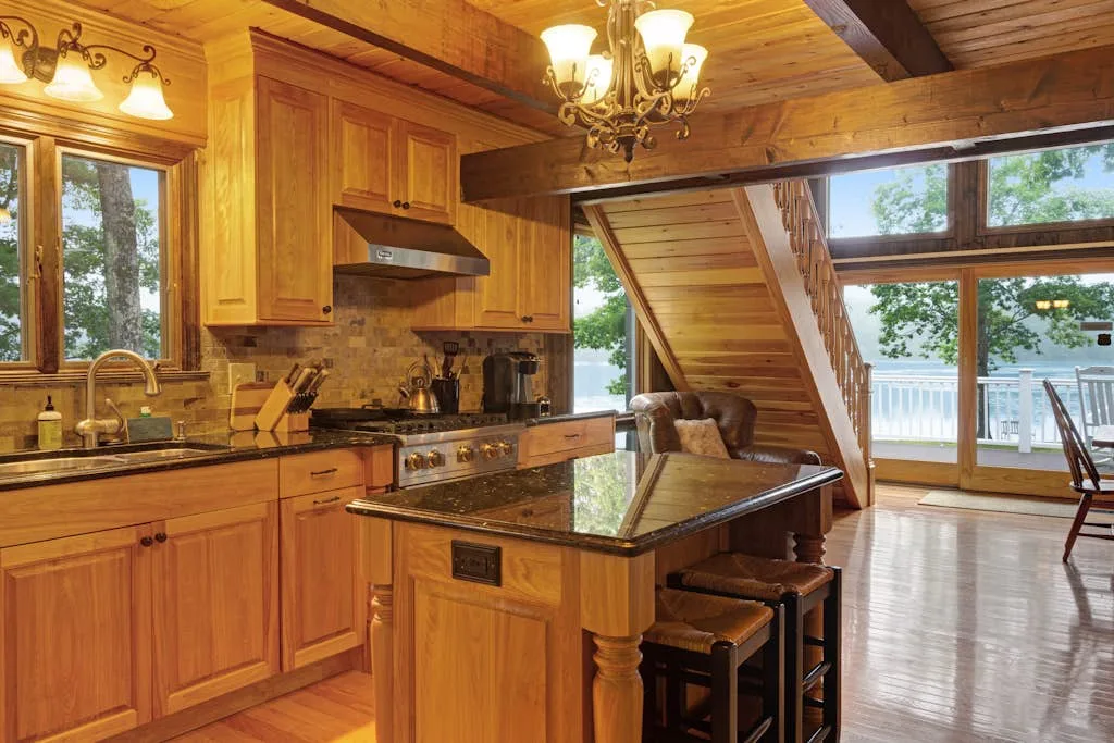 A wood-paneled kitchen with a central island opens onto a bright dining area.