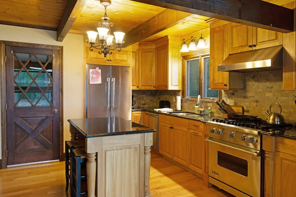 A wood-paneled kitchen with a central island and stainless steel appliances.