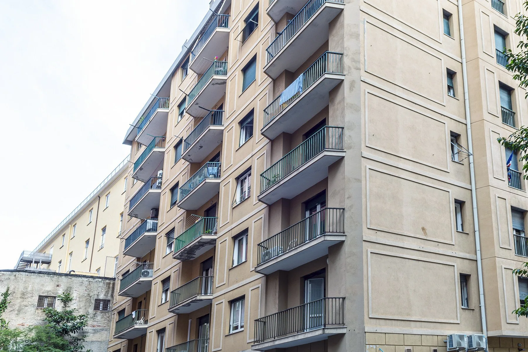 Apartment buildings with rows of balconies line a city street.