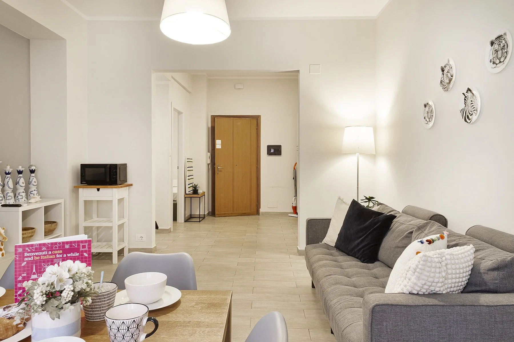 A bright living room with seating, a coffee table, and a doorway in the background.