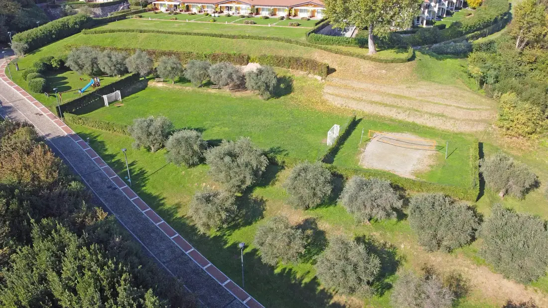 An aerial view of a landscaped outdoor recreation area with lawns and a path.