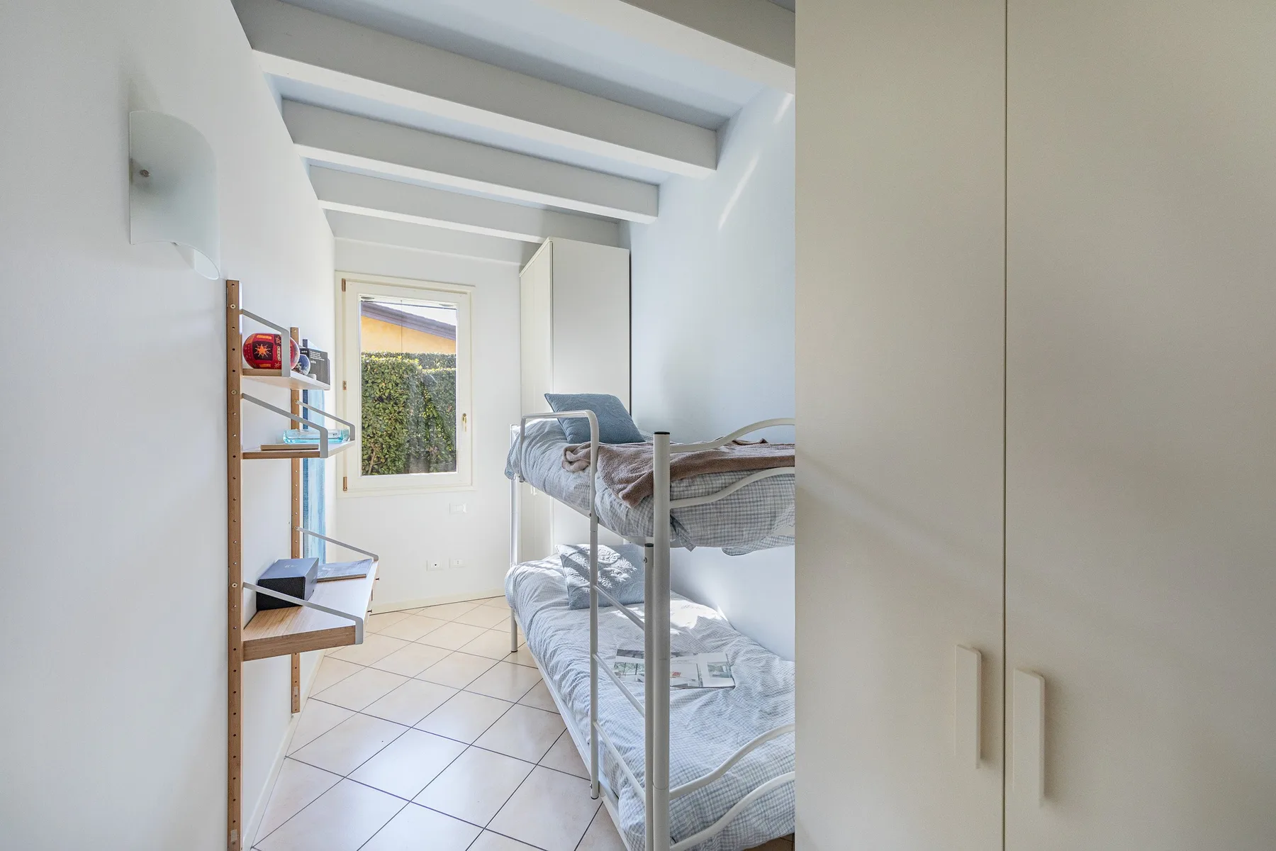 A bright bedroom with bunk beds and a window.