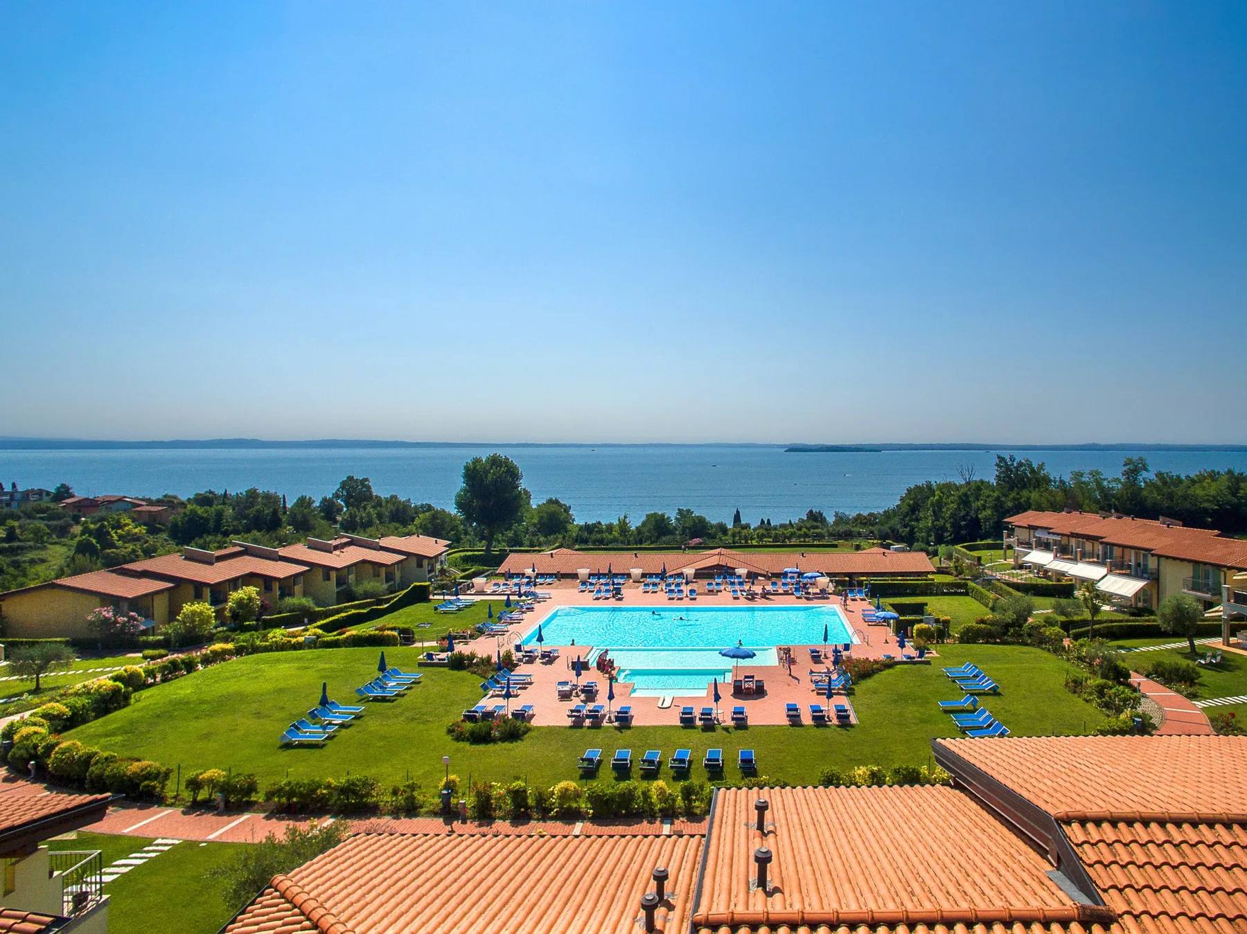 A landscaped resort grounds with a swimming pool and the sea beyond.