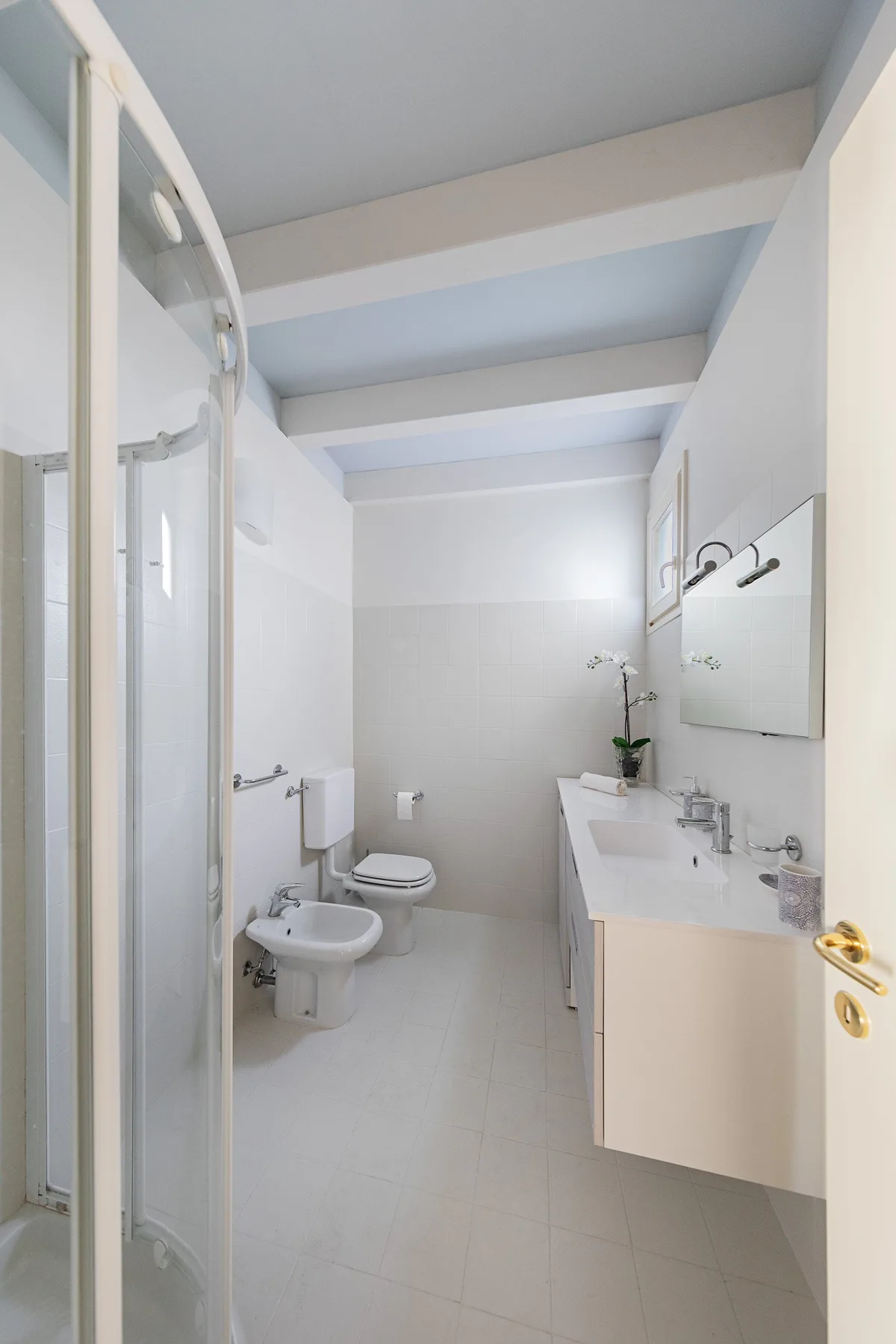 A bright bathroom with a shower, toilet, and sink.