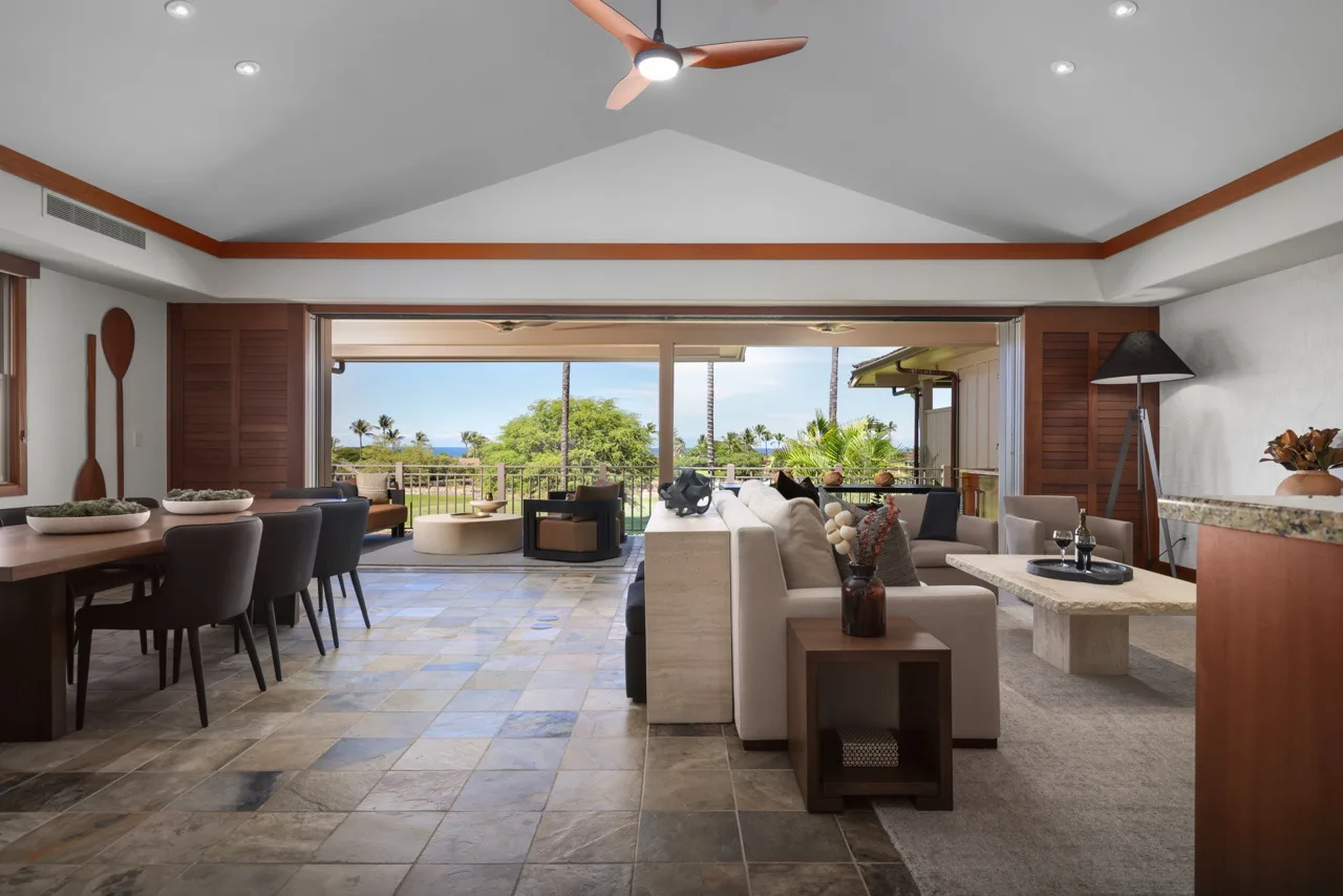 An open-plan living and dining area overlooks a patio through wide glass doors.