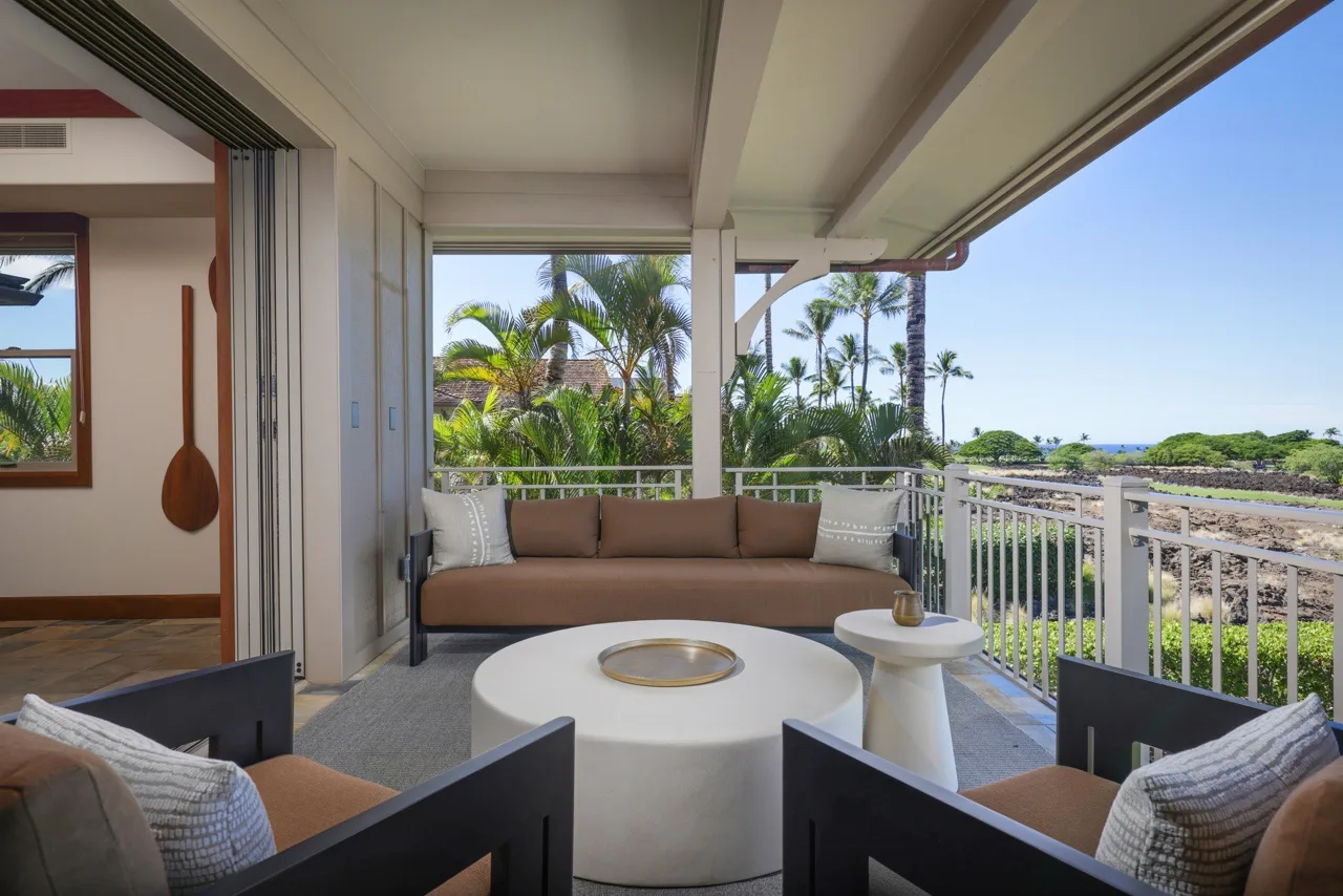 A covered outdoor seating area overlooks palm trees and the surrounding landscape.