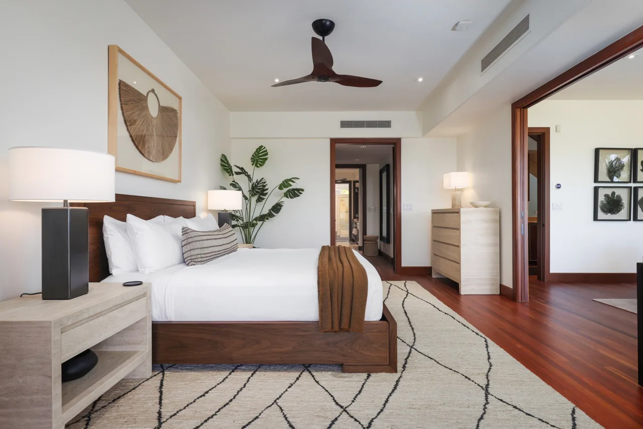 A bedroom with a bed, bedside tables, and a patterned rug.