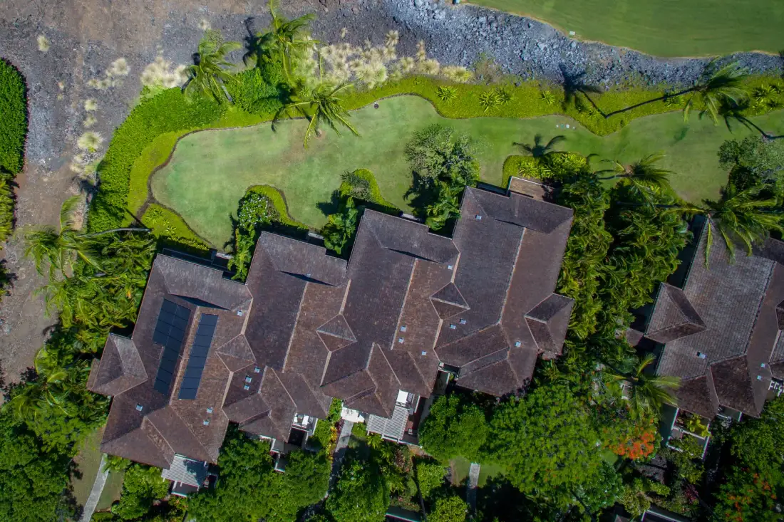 Aerial view of several buildings beside a landscaped green lawn.