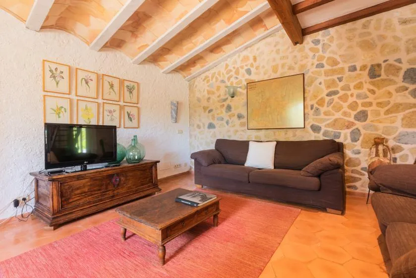 A living room with a sofa, television, and wooden coffee table.