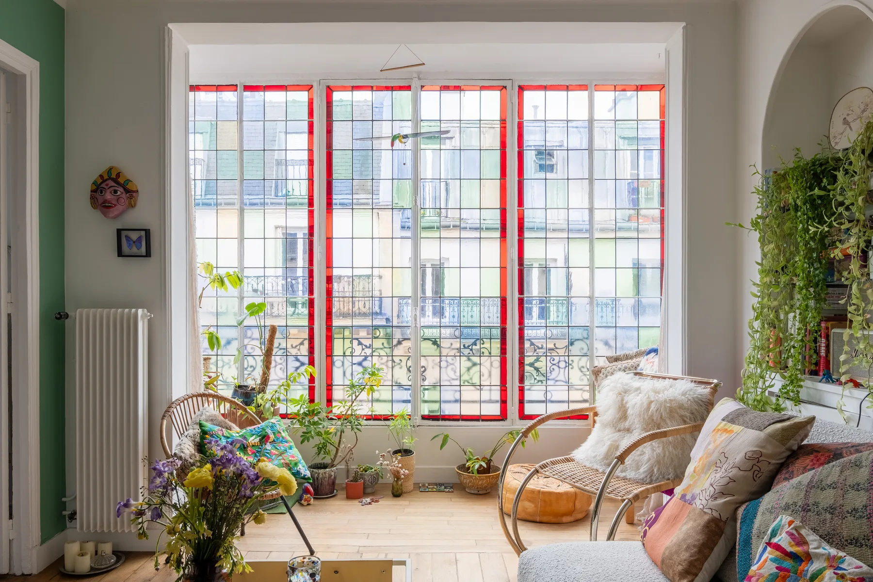 Una luminosa sala de estar con grandes ventanas, asientos y plantas.