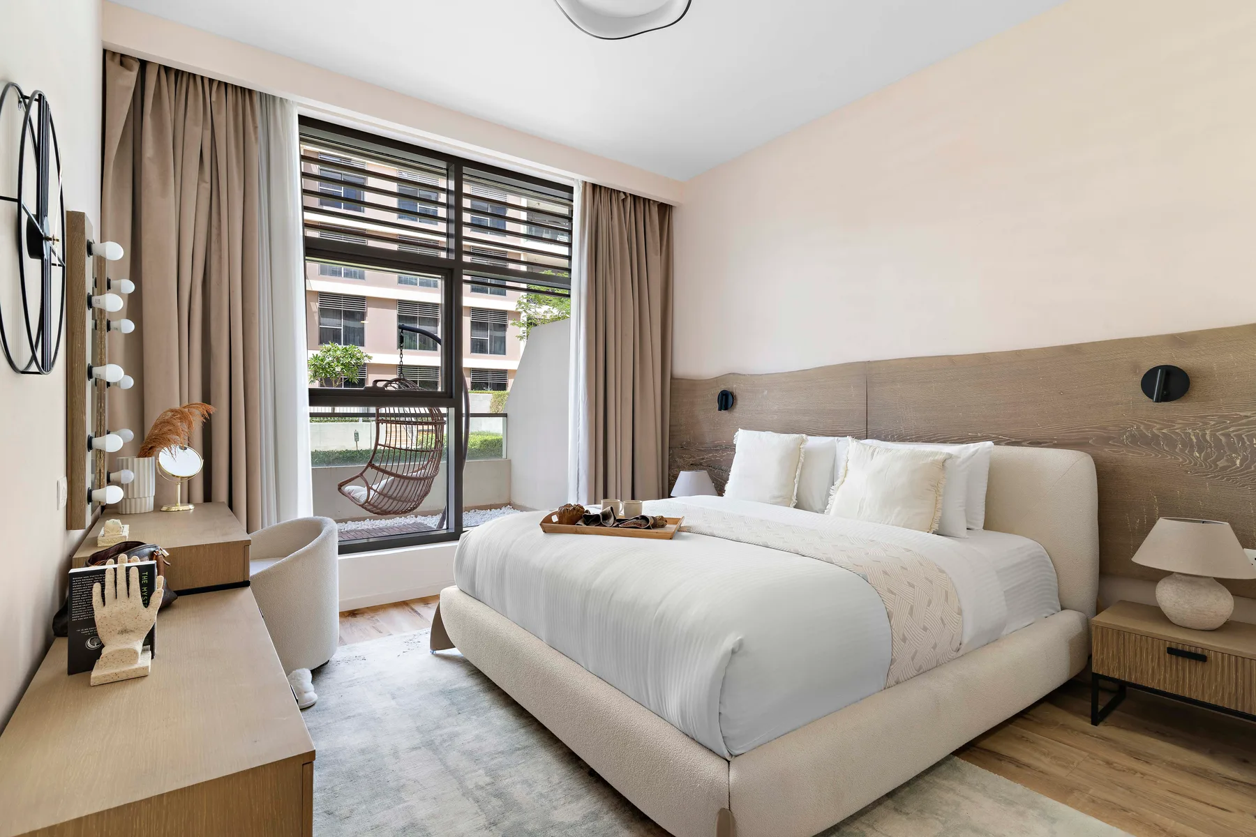 Un dormitorio luminoso con una cama hecha y una ventana amplia.