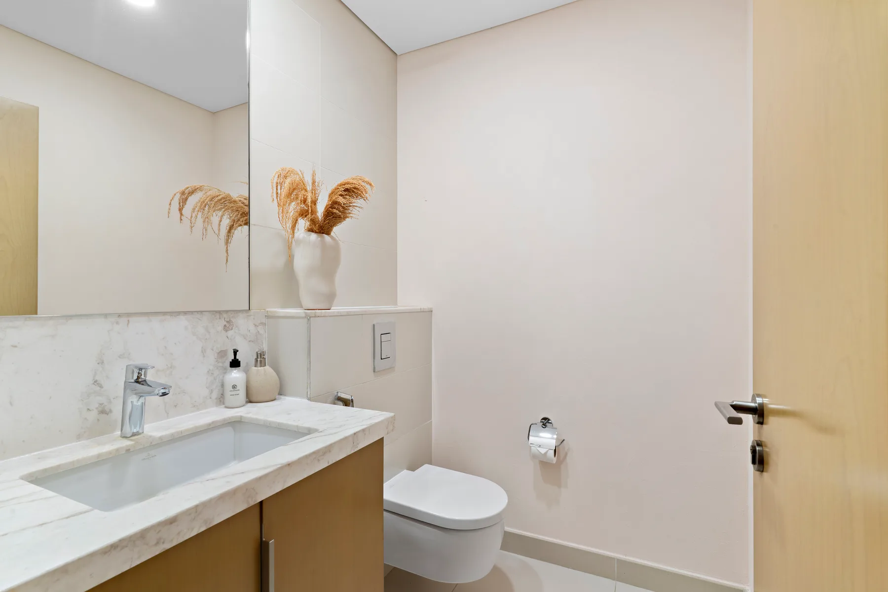 Un baño con lavabo, espejo e inodoro.