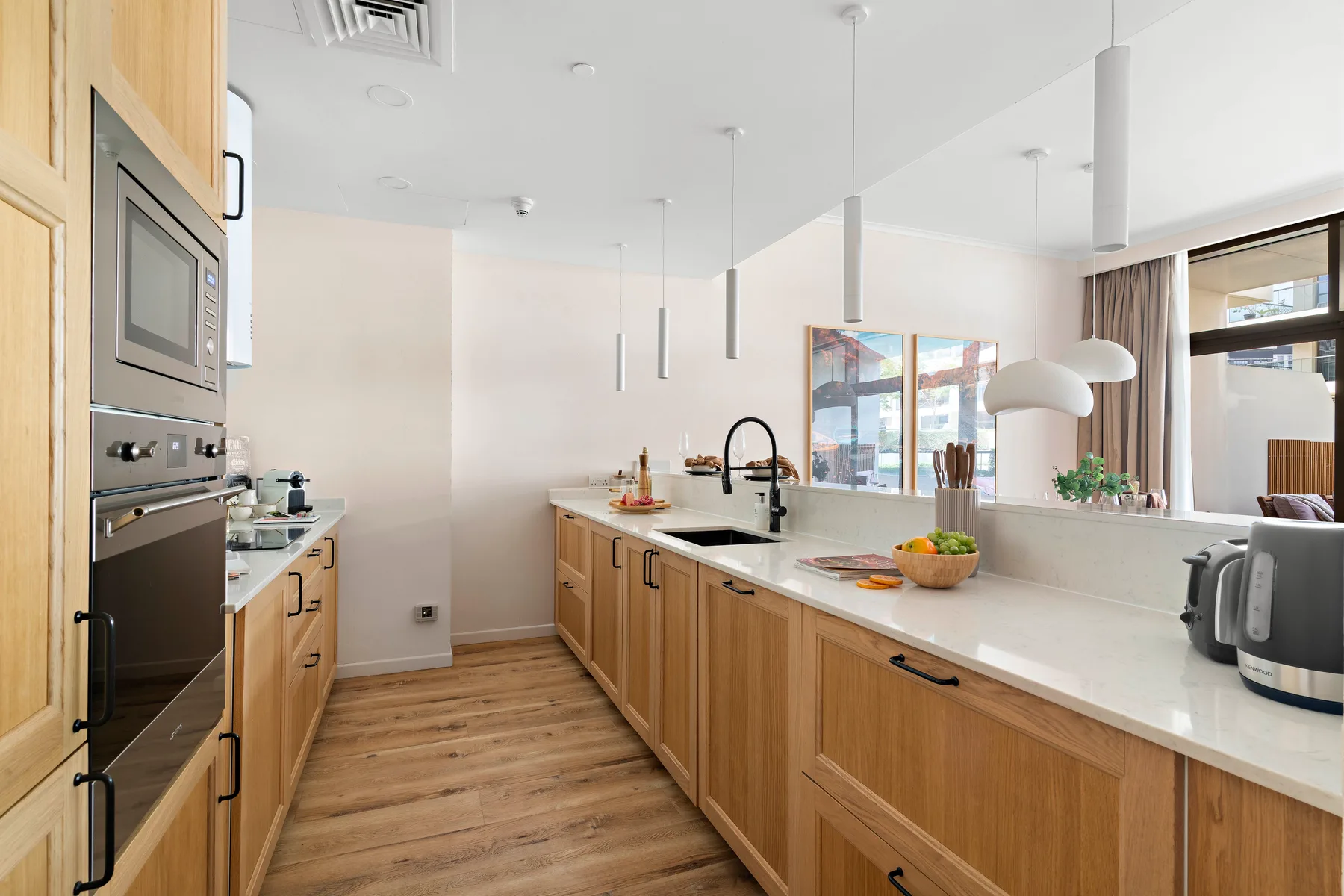 Una cocina moderna y luminosa con gabinetes de madera clara y una isla central.