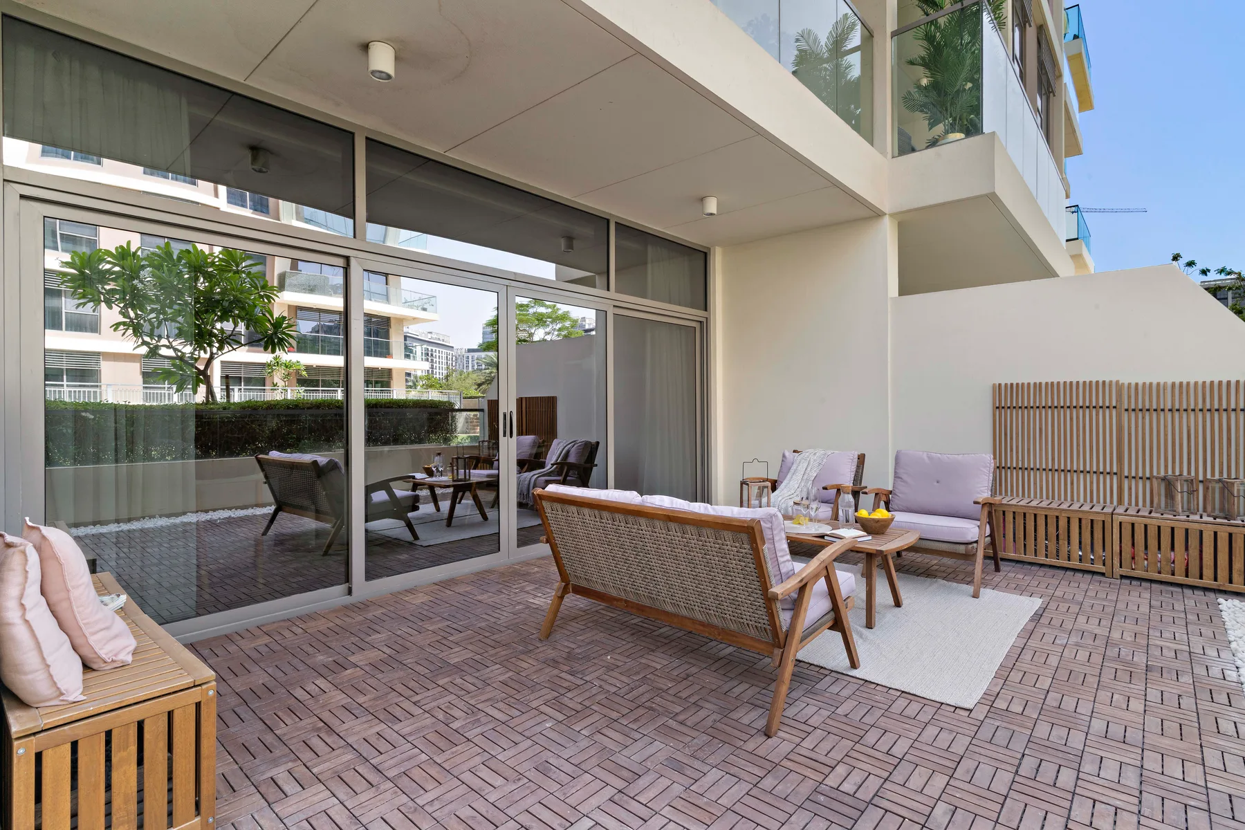 Un patio exterior con asientos y grandes puertas de vidrio.