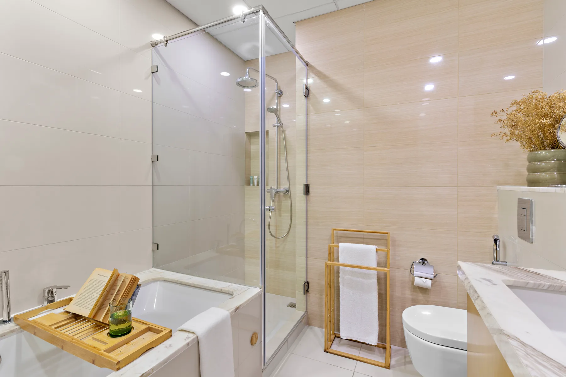 Un baño con azulejos, ducha de vidrio, bañera y lavabo.
