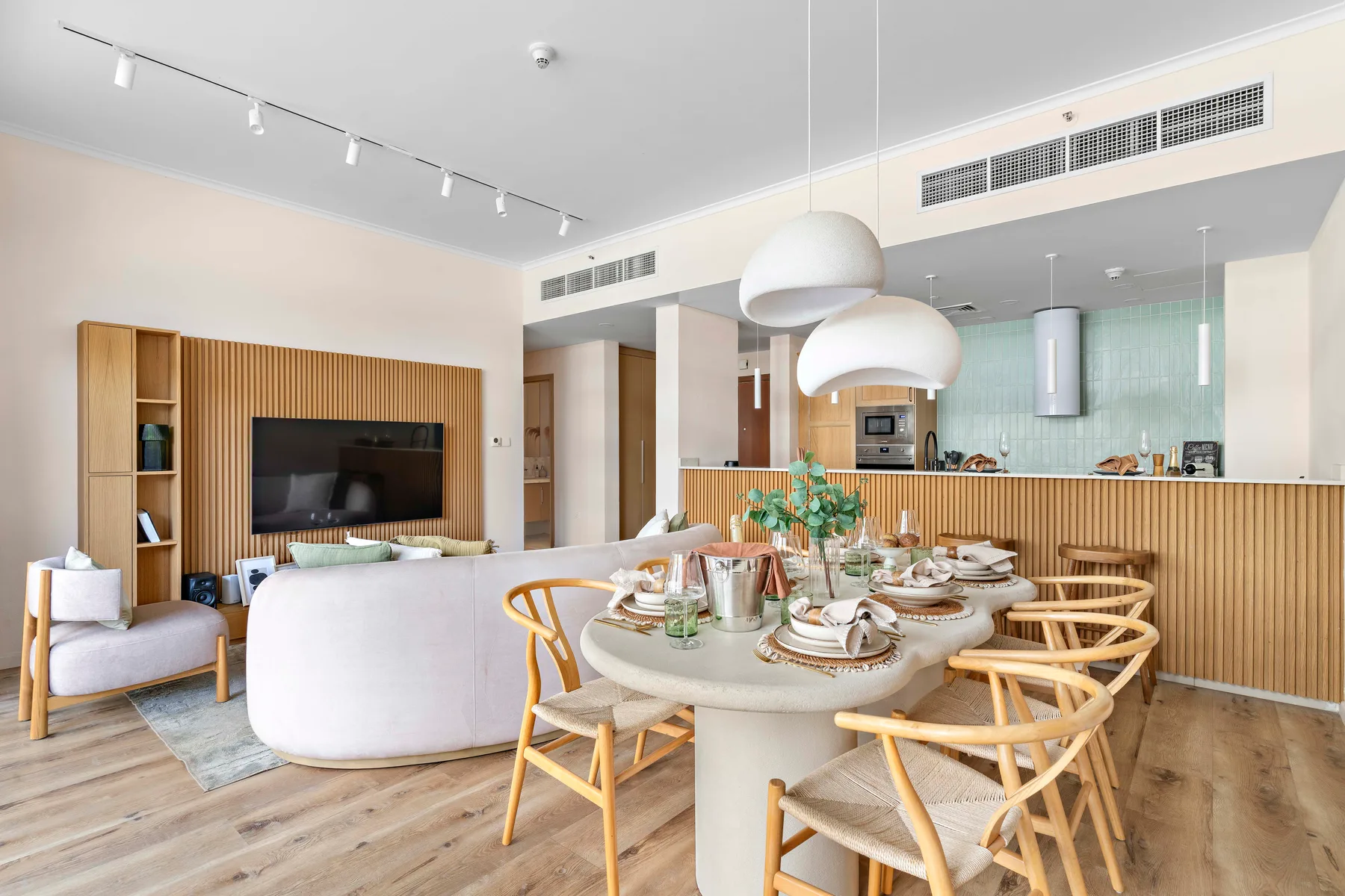 Una sala-comedor de concepto abierto tiene una mesa junto a una zona de estar.