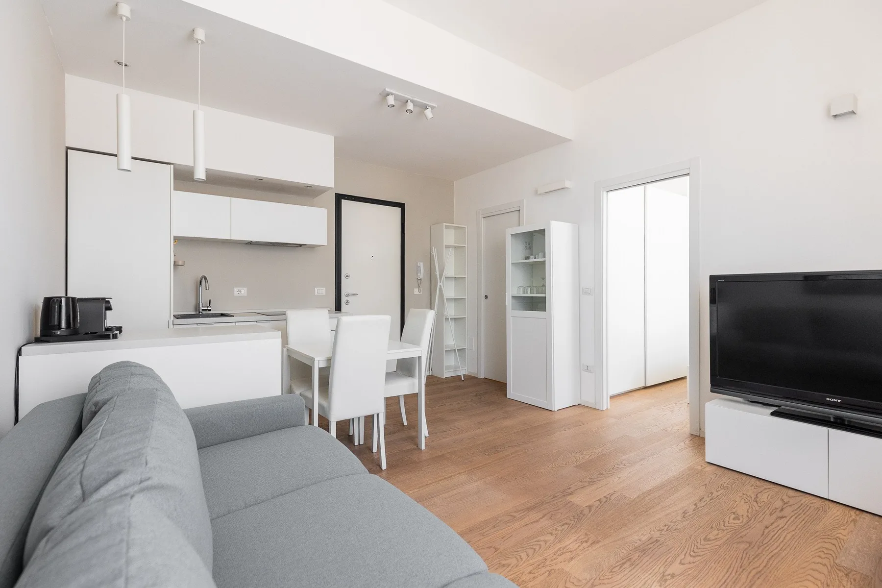 Una sala luminosa con asientos, una mesa de comedor y un televisor.
