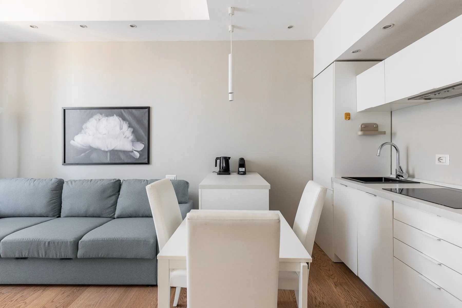 Un comedor luminoso con una mesa, asientos y una cocina compacta.
